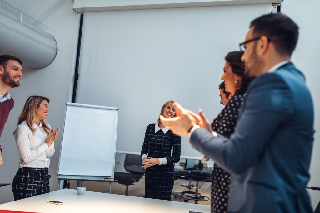 Group of employees saying well done to each other
